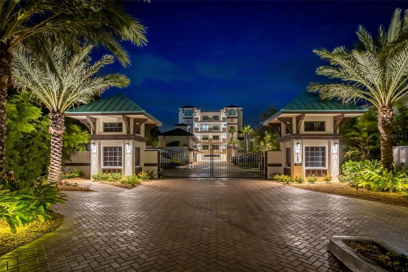 Gated luxury condominium entrance at night with palm trees in Tampa Bay